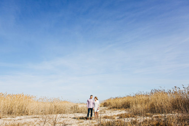 Engaged couple pose in Ocean City, NJ during their winter beach portrait session.