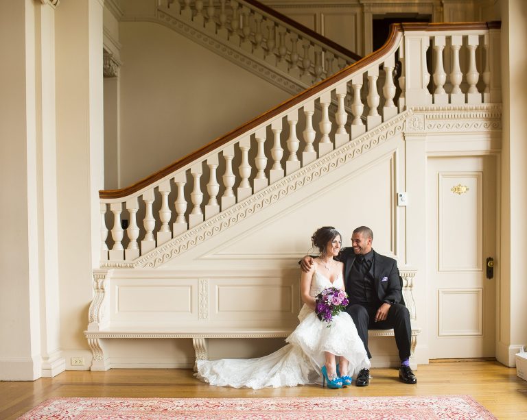 Bride and groom sit together in front of staircase at Cairnwood Estate after their first look.