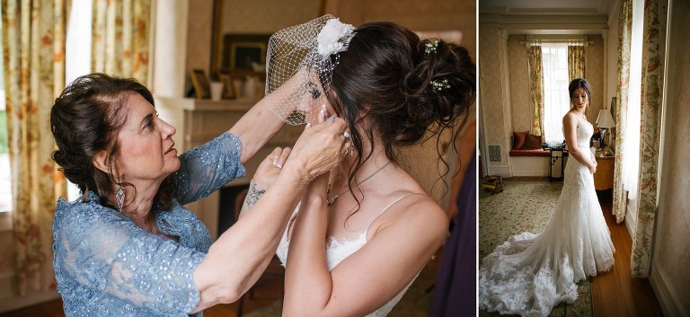 Mom helps bride put on veil and bride stands at window in Cairnwood Estate.