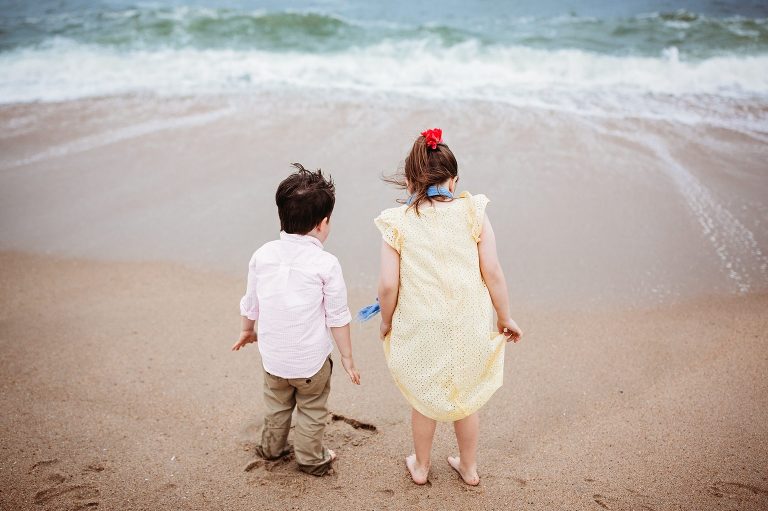 A brother and sister wait for the waves to come at Belmar beach